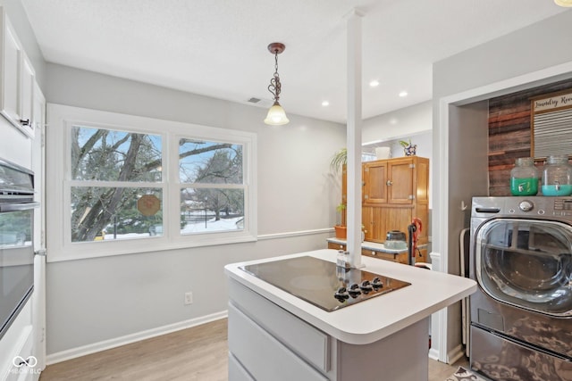 laundry area with washer / clothes dryer and light wood-type flooring