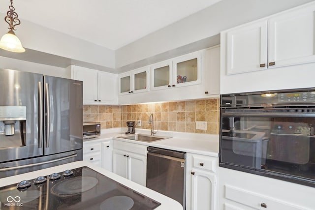 kitchen featuring pendant lighting, sink, black appliances, and white cabinets