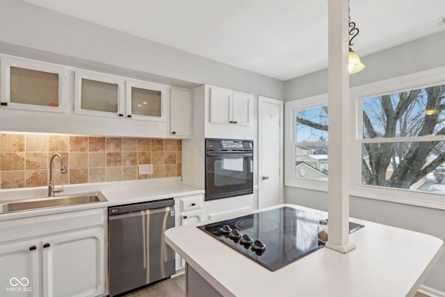 kitchen featuring sink, white cabinetry, black appliances, decorative backsplash, and decorative light fixtures