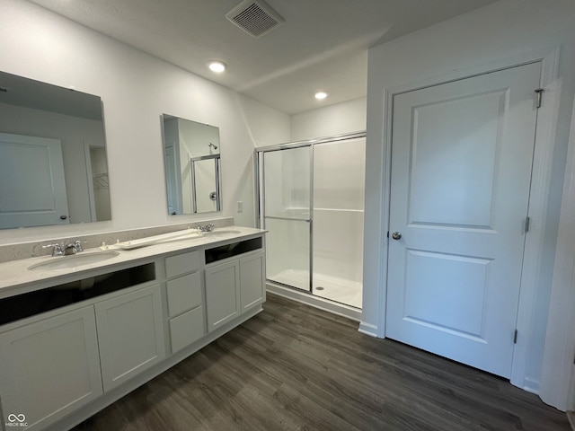 bathroom with an enclosed shower, vanity, and wood-type flooring