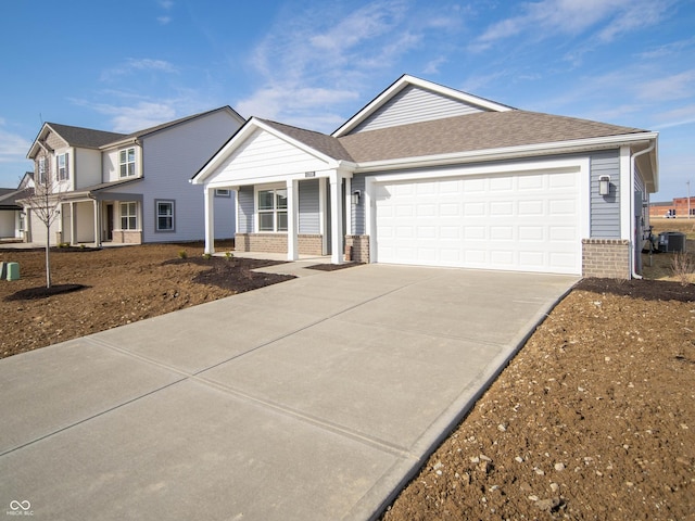 single story home with a garage, central AC, and covered porch