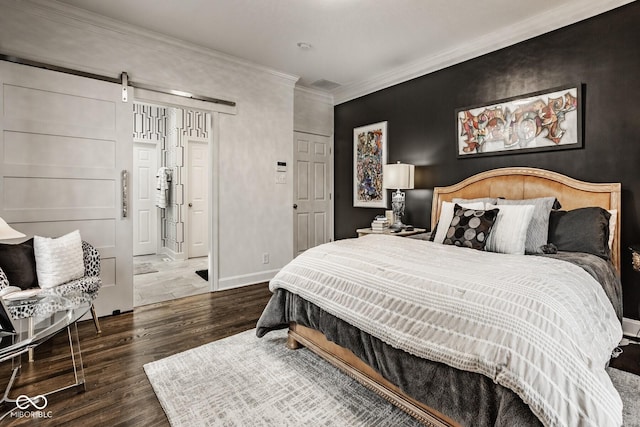 bedroom featuring ornamental molding, a barn door, and dark hardwood / wood-style flooring