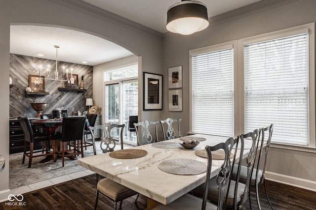 dining space featuring an inviting chandelier, wood-type flooring, and ornamental molding