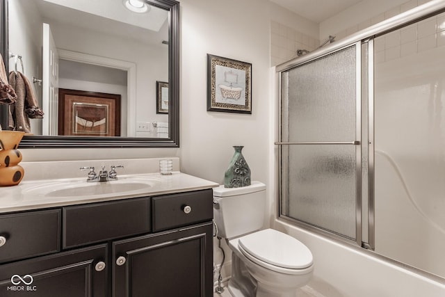 full bathroom featuring enclosed tub / shower combo, vanity, and toilet