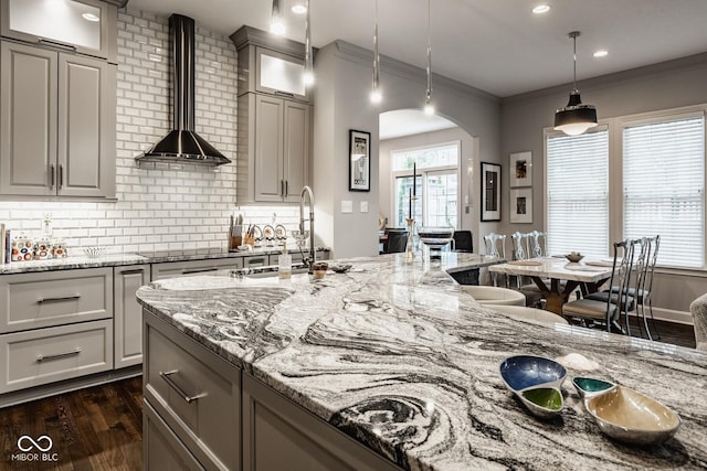 kitchen featuring dark hardwood / wood-style flooring, decorative light fixtures, and light stone countertops