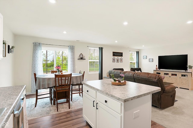 kitchen with light hardwood / wood-style flooring, a kitchen island, and white cabinets