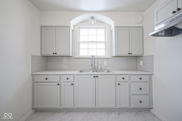 kitchen with white cabinetry, sink, and backsplash