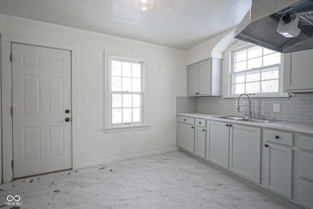 kitchen featuring gray cabinetry, sink, backsplash, and extractor fan