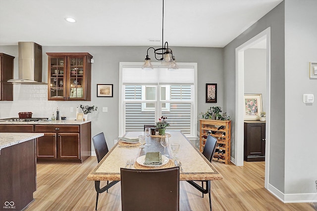 dining space featuring an inviting chandelier and light hardwood / wood-style floors