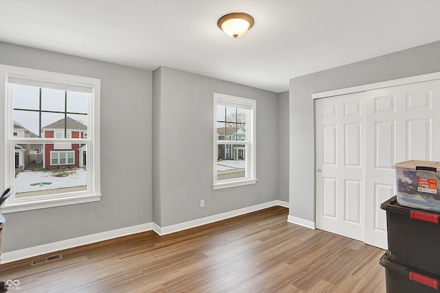 unfurnished bedroom featuring wood-type flooring and a closet