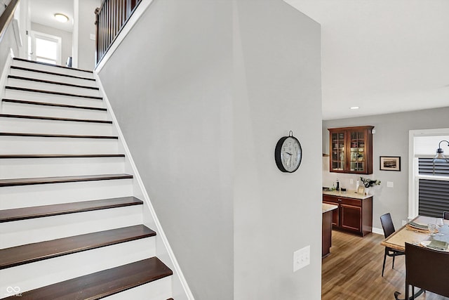 staircase featuring hardwood / wood-style floors and indoor bar