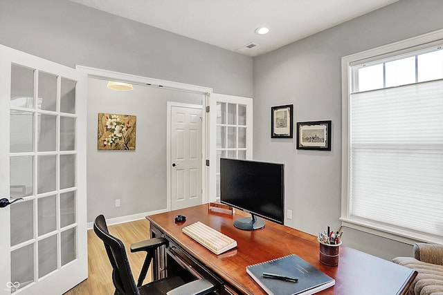 office space with light wood-type flooring and french doors