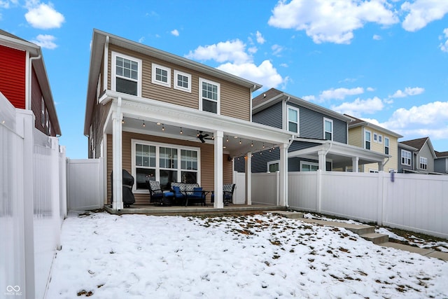 snow covered rear of property with ceiling fan