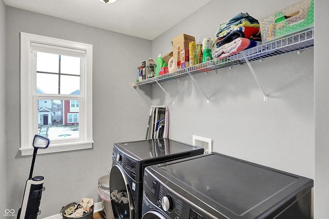 laundry room with washing machine and dryer and a healthy amount of sunlight