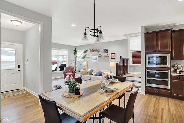 dining space with a chandelier and light wood-type flooring