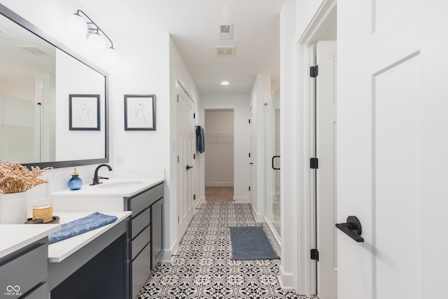 bathroom with tile patterned flooring, vanity, and an enclosed shower