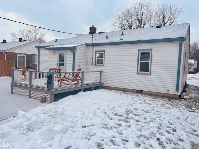 snow covered rear of property with a wooden deck