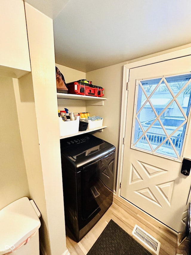 clothes washing area featuring washer / dryer and light wood-type flooring