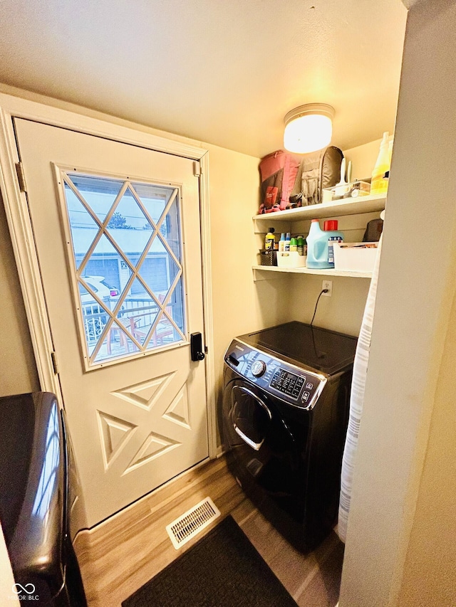 washroom with wood-type flooring and separate washer and dryer