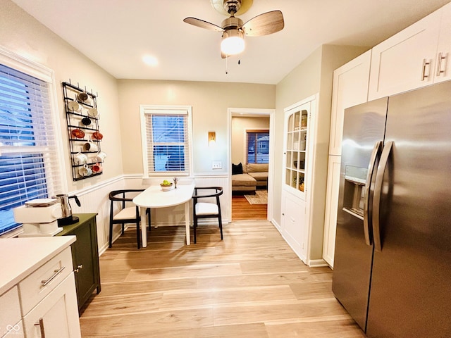 kitchen featuring stainless steel refrigerator with ice dispenser, white cabinetry, ceiling fan, and light hardwood / wood-style floors