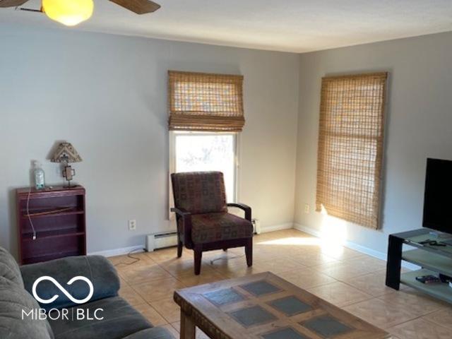 living room with ceiling fan and baseboard heating