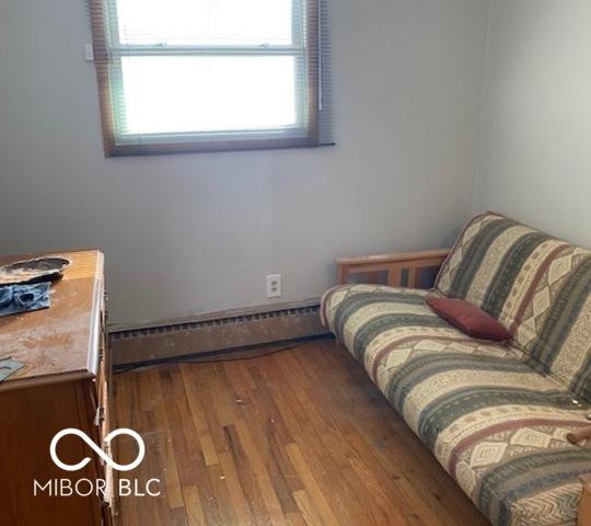 bedroom with hardwood / wood-style flooring and a baseboard heating unit