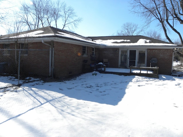 view of snow covered rear of property