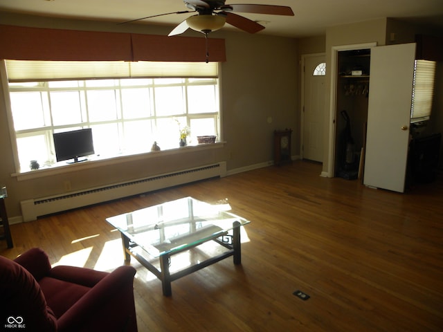 living room featuring a baseboard heating unit, wood-type flooring, and ceiling fan