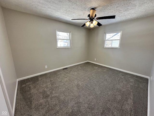 carpeted spare room featuring ceiling fan and a textured ceiling