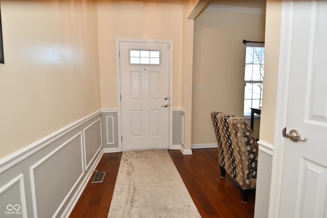 foyer with ornamental molding, dark hardwood / wood-style floors, and a wealth of natural light