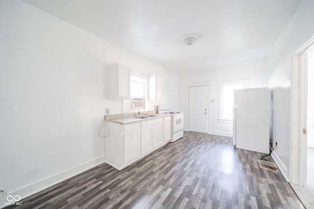 interior space with sink, white appliances, plenty of natural light, and white cabinets