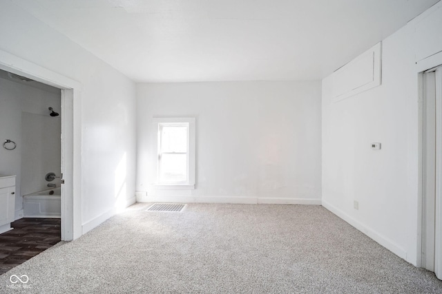 spare room featuring dark carpet