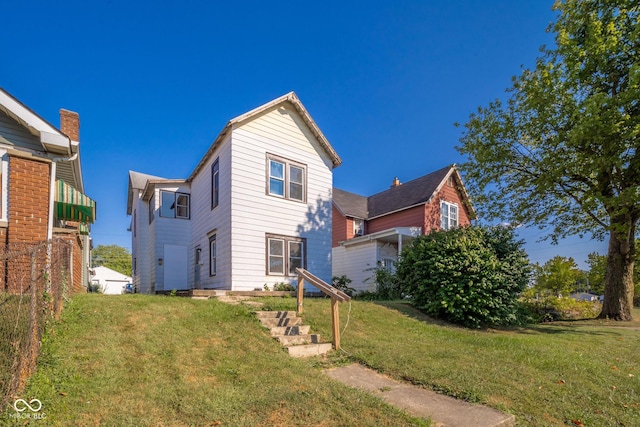 rear view of property featuring a yard