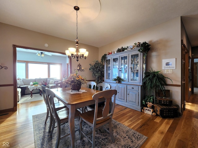 dining area with light hardwood / wood-style flooring and a chandelier