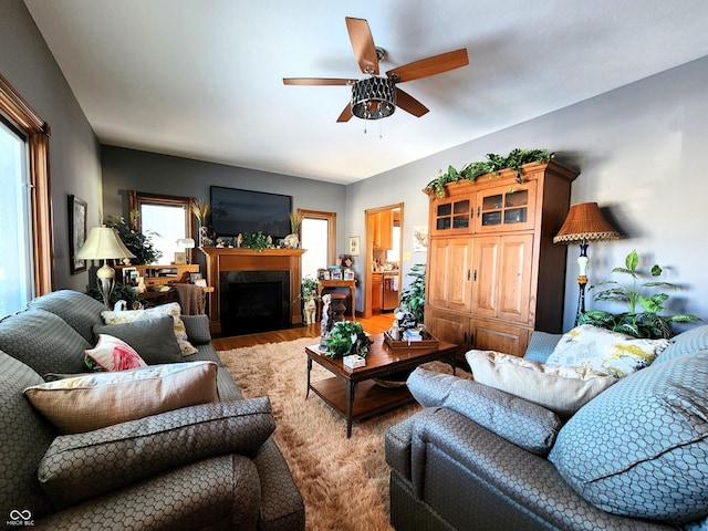 living room with light hardwood / wood-style flooring, ceiling fan, and plenty of natural light