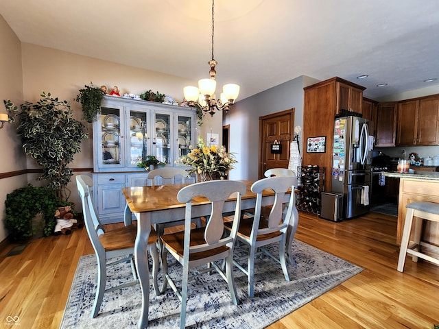 dining room featuring an inviting chandelier and light wood-type flooring