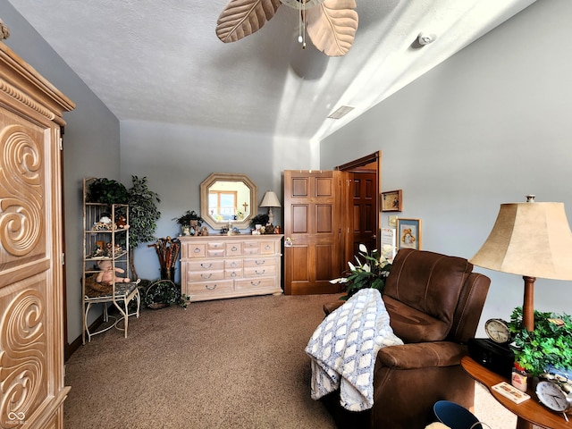 sitting room with ceiling fan, lofted ceiling, carpet, and a textured ceiling