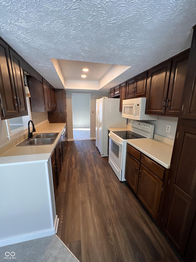 kitchen featuring sink, white appliances, a tray ceiling, a textured ceiling, and dark hardwood / wood-style flooring