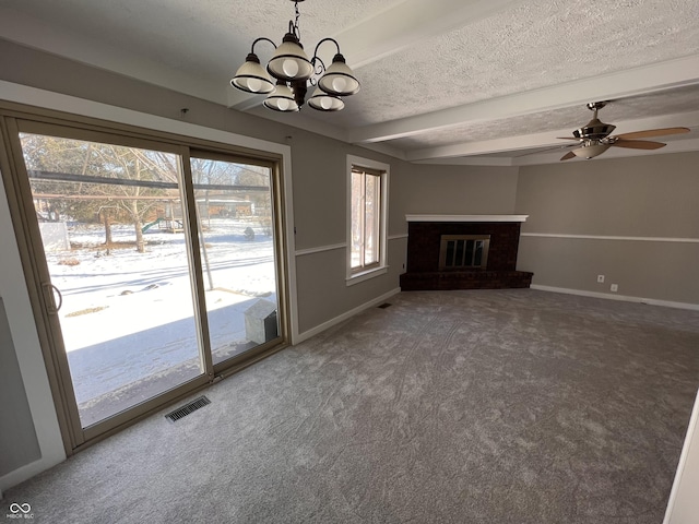 unfurnished living room featuring a brick fireplace, a wealth of natural light, carpet, and a textured ceiling