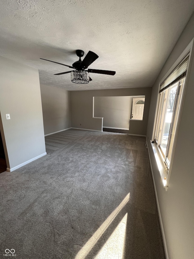 carpeted spare room with ceiling fan and a textured ceiling