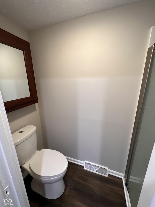 bathroom featuring hardwood / wood-style flooring and toilet