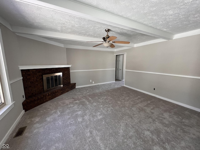 unfurnished living room with ceiling fan, carpet, a textured ceiling, a brick fireplace, and beamed ceiling