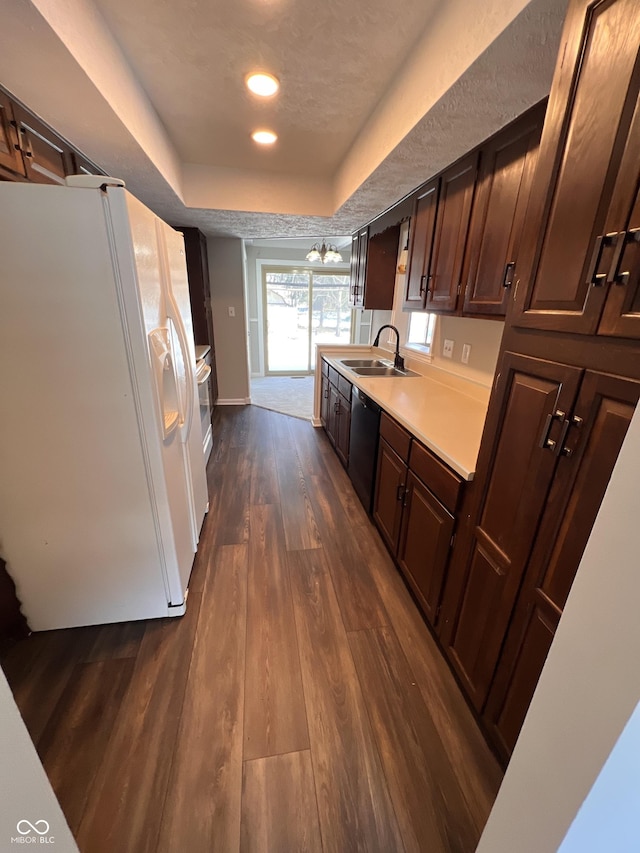 kitchen featuring sink, dishwasher, white refrigerator with ice dispenser, dark hardwood / wood-style flooring, and a raised ceiling