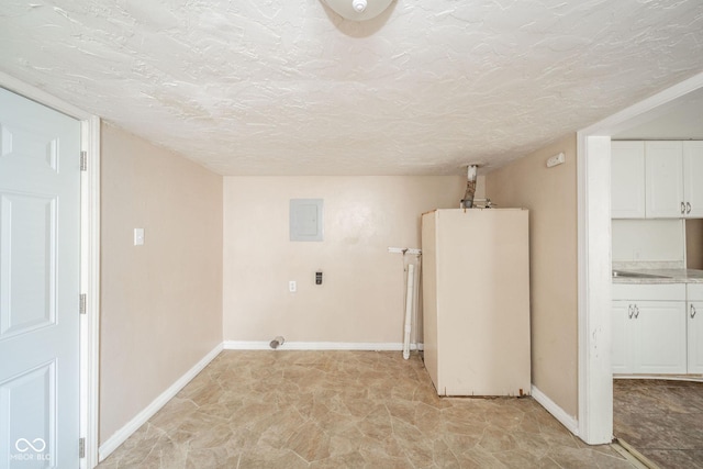 laundry room with electric panel and a textured ceiling