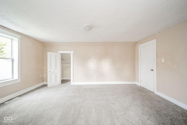 empty room featuring carpet floors and a textured ceiling