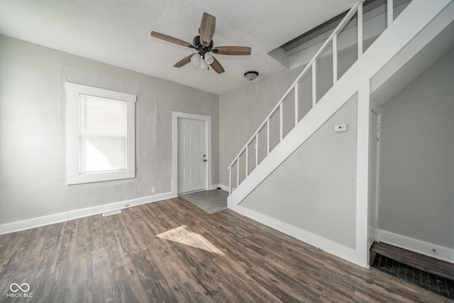 interior space featuring dark wood-type flooring, a textured ceiling, and ceiling fan