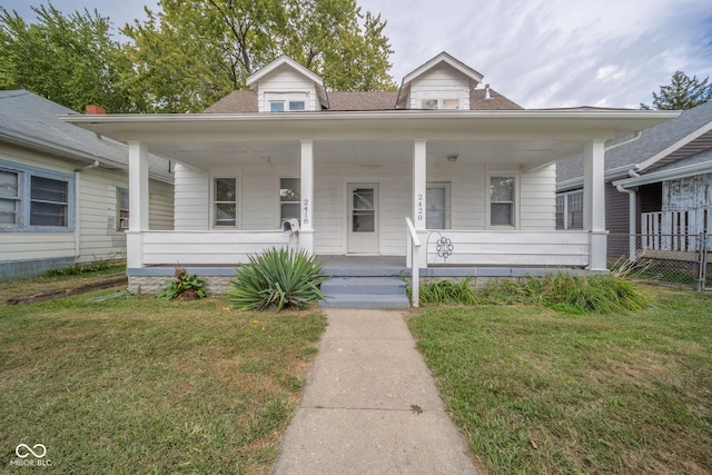 bungalow with a front yard and covered porch