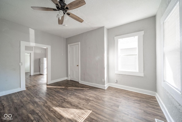 interior space featuring dark hardwood / wood-style flooring, a textured ceiling, ceiling fan, and white fridge