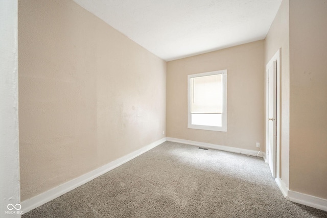 empty room with carpet flooring and vaulted ceiling