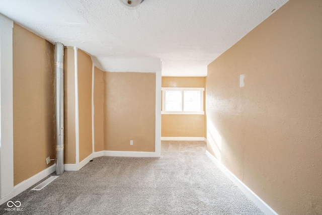 spare room featuring carpet and a textured ceiling